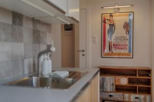 una cocina con fregadero y un cartel de una mujer en Tyzenhauz Apartments Dietla Street, en Cracovia
