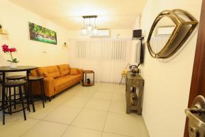a living room with a couch and a table at הטרקלין של שלמה. דירה יפה וחדשה 5 דקות נסיעה מהים in Ashqelon