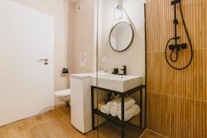 a bathroom with a sink and a toilet and a mirror at Schiller Studio 64 - free private parking in Braşov