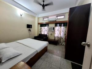 Hotel Tawang Inn في تاوانج: غرفة نوم بسرير وكرسي في غرفة