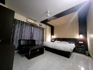 Hotel Tawang Inn في تاوانج: غرفة نوم بسرير وكرسي وطاولة