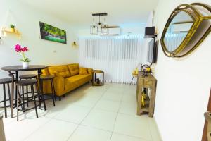 sala de estar con sofá amarillo y mesa en הטרקלין של שלמה. דירה יפה וחדשה 5 דקות נסיעה מהים en Ashkelon
