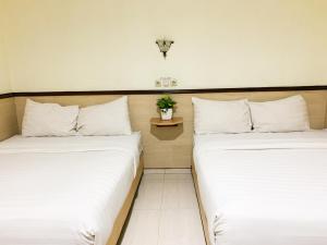 日惹的住宿－Musafira Hotel Syariah Malioboro Yogyakarta Mitra RedDoorz，两张睡床彼此相邻,位于一个房间里