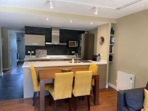 a kitchen with a wooden table and yellow chairs at Les Ferreries Saillagouse in Saillagouse