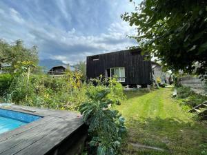 une maison avec une terrasse en bois et une piscine dans l'établissement La tiny house de Chaparon, à Lathuile
