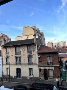 un antiguo edificio de ladrillo en una calle de la ciudad en Luminous appartment in Paris with balcony en Aubervilliers