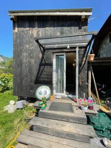 a small wooden house with a door and some plants at La tiny house de Chaparon in Lathuile