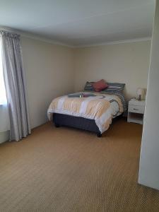 1 dormitorio con 1 cama en una habitación con ventana en Sapphire Guest House en Germiston