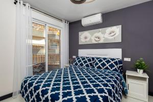 sypialnia z niebiesko-białym łóżkiem i oknem w obiekcie Apartamento Baltico, 50m to Los Locos Beach w mieście Torrevieja +12 zdjęć