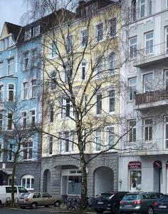 a tall building with cars parked in front of it at Bude 1: Liebevoll saniert & komfortabel in Kiel