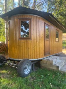 ein winziges Holzhaus auf einem Wohnwagen im Gras in der Unterkunft La barrique in Faymont