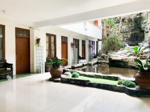 ein Wohnzimmer mit einem Fischteich in der Mitte in der Unterkunft Musafira Hotel Syariah Malioboro Yogyakarta Mitra RedDoorz in Yogyakarta