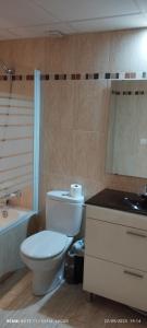 a bathroom with a toilet and a sink and a tub at Camino de la Sierra Mascotas SI in La Zubia