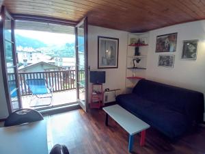 een woonkamer met een bank en een balkon bij La casa nel cuore di La Thuile in La Thuile