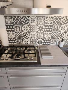 uma cozinha com um fogão e uma parede de azulejos em Studio Pollestres em Pollestres
