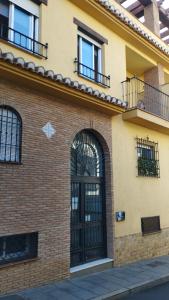 a brick building with a black door and windows at Camino de la Sierra Mascotas SI in La Zubia