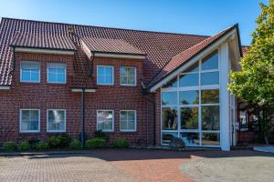 a red brick house with large windows at Landhotel Elkemann in Ahaus