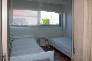 Habitación pequeña con 2 camas y ventana en Maravilloso apartamento de playa en la paradisíaca Illa de Arousa, en A Illa de Arousa