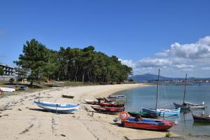 un grupo de barcos sentados en la playa en Maravilloso apartamento de playa en la paradisíaca Illa de Arousa, en A Illa de Arousa