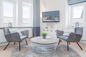 uma sala de estar com duas cadeiras e uma mesa de centro em Tanneneck Wohnung 2 em Travemünde