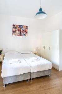 een bed in een slaapkamer met een schilderij aan de muur bij Ziv Apartments - Gottlieb 4 in Tel Aviv