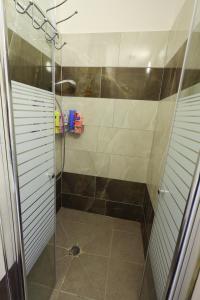 La salle de bains est pourvue d'une douche avec une porte en verre. dans l'établissement דירה יפה סגנון מודרני מרחק של 5 דקות נסיעה מהים, à Ashkelon