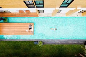 an overhead view of a person and a dog in a pool at Book a Bed Poshtel - SHA Plus in Phuket