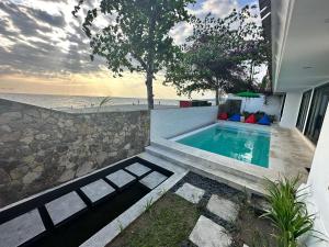 MontongbuwohにあるVilla Pantaiの海の家の前のスイミングプール