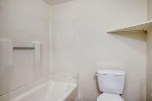 La salle de bains blanche est pourvue de toilettes et d'une baignoire. dans l'établissement South Boston 1br w building wd nr seaport BOS-913, à Boston