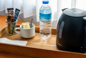 a bottle of water and a toaster on a wooden tray at Landhotel Elkemann in Ahaus