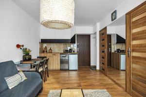 een keuken en een woonkamer met een bank en een tafel bij Jana Pawła II Comfort Apartments by Rentujemy in Warschau