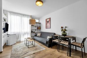een woonkamer met een bank en een tafel bij Jana Pawła II Comfort Apartments by Rentujemy in Warschau