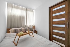 een slaapkamer met een bed met een tafel erop bij Jana Pawła II Comfort Apartments by Rentujemy in Warschau