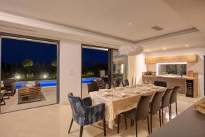 Un comedor con una mesa larga y sillas. en Spuga, en Brodarica