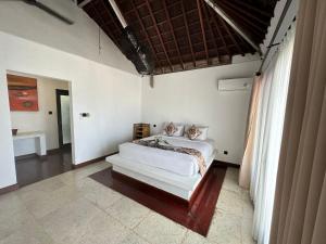 MontongbuwohにあるVilla Pantaiの部屋の中央にベッドが置かれた寝室 +6枚の写真