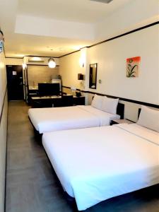 a hotel room with three beds and a piano at Toyoko Inn Cebu in Cebu City