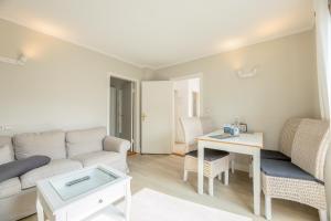 una sala de estar con un sofá y una mesa en Bungalow Flora, en Westerland