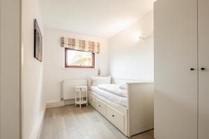 Un dormitorio pequeño con una cama y una ventana. en Bungalow Flora, en Westerland