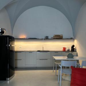 une cuisine avec un évier et une table avec des chaises dans l'établissement Stanza22, à Ceglie Messapica