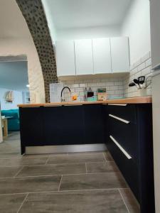 a kitchen with black and white cabinets and a tile floor at Casa Paula in Las Playitas