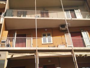 an apartment building with white balconies and red doors at la casa di Aldo in Perugia