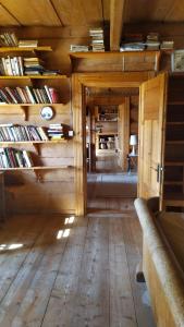 a room with wooden floors and shelves with books at Dom na Pawlikach in Rzepiska