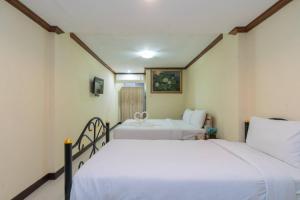 two beds in a room with white sheets at Blueskyhouse Patong in Patong Beach