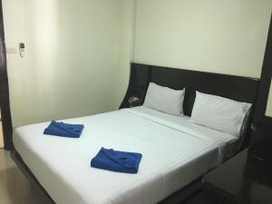a bed with two blue towels on top of it at Blueskyhouse Patong in Patong Beach