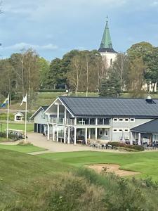 a building on a golf course with a green at Åvillan - River house in Lagan