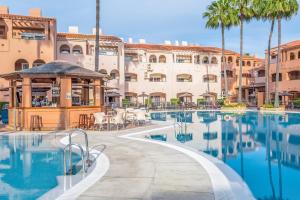 una piscina resort con cenador y palmeras en Los Amigos Beach Club, en La Cala de Mijas