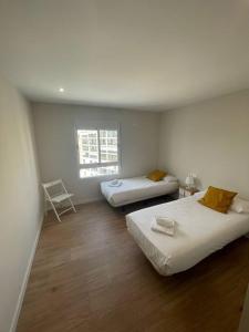 Cette chambre comprend 2 lits et une fenêtre. dans l'établissement Apartamento céntrico de diseño en calle Tres Forques,Valencia, à Valence