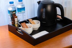 a tray with a tea kettle and cups on a table at Landhotel Elkemann in Ahaus