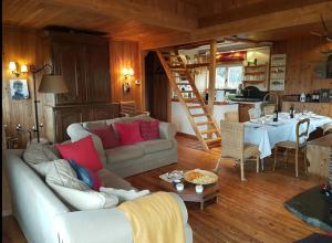 ein Wohnzimmer mit einem Sofa und einem Tisch sowie eine Küche in der Unterkunft Woodstone in Herbeumont