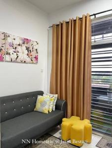 a living room with a couch and a window at NN Homestay @ Jasin Bestari in Kampong Bemban